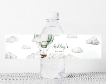 May include: Water bottle label with a green and white hot air balloon with clouds and the text "Ashley's Baby Shower".