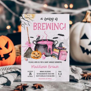 A Halloween-themed baby shower invitation featuring a pot of bubbling pink liquid, jack-o-lanterns, and bats, with a pumpkin and broom in the background.