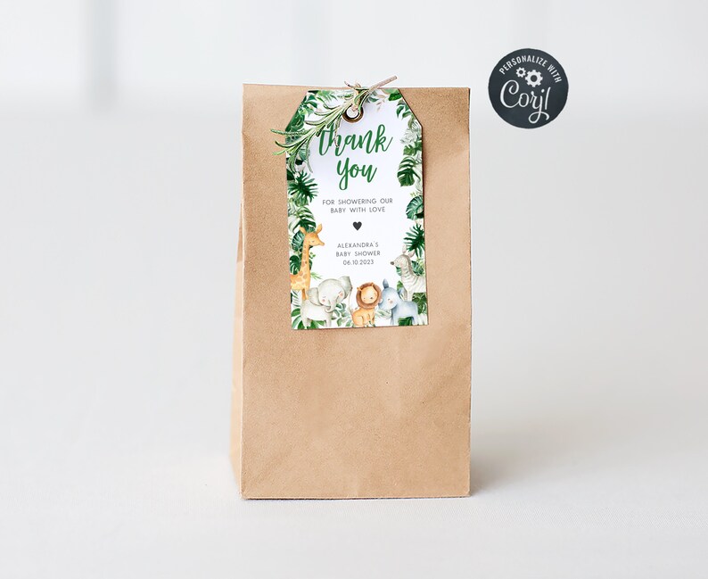May include: A brown paper bag with a thank you tag attached. The tag has a jungle animal theme with a giraffe, lion, elephant, and zebra. The text on the tag reads "Thank you for showering our baby with love, Alexandra's Baby Shower, 04.10.2023".