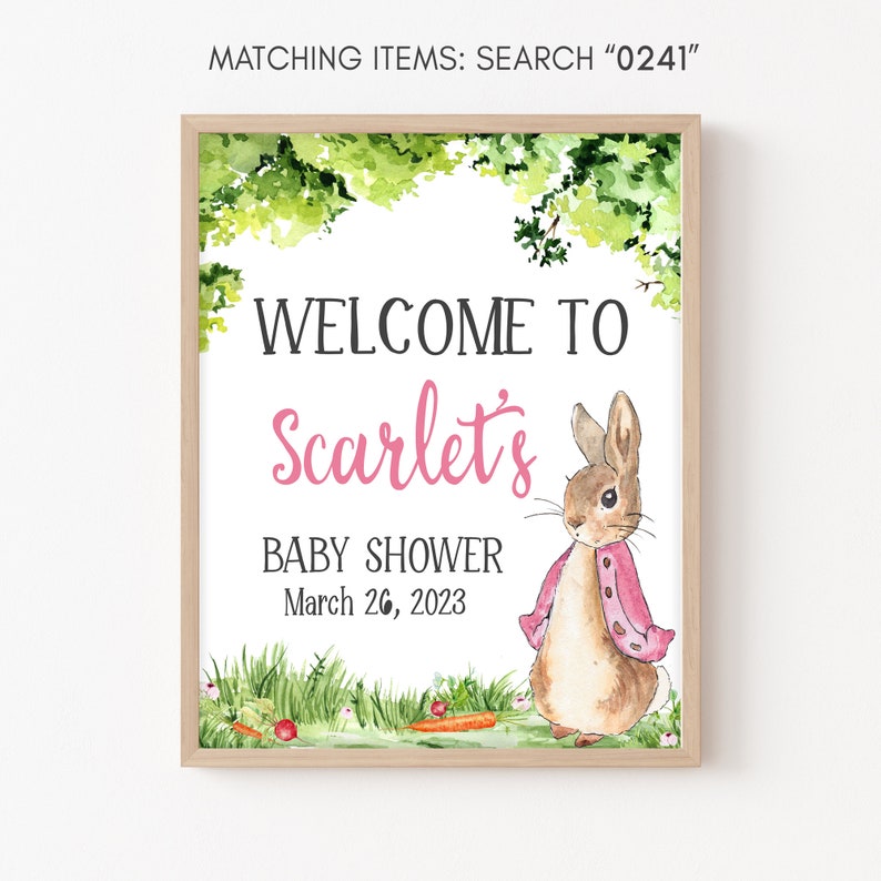 May include: A welcome sign for a baby shower with a watercolor illustration of a brown rabbit wearing a pink cardigan. The sign says "Welcome to Scarlet's Baby Shower March 26, 2023".