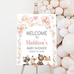 a baby shower sign with balloons in the background