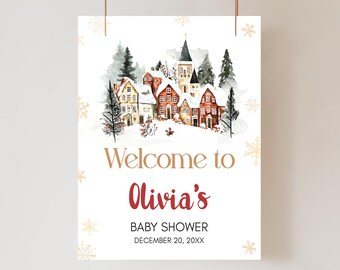 Peut inclure: Une affiche blanche avec une illustration à l'aquarelle d'un village enneigé. Le texte "Welcome to Olivia's" est en or et rouge, avec "BABY SHOWER" et la date en dessous. Des flocons de neige dorés ornent les bords.
