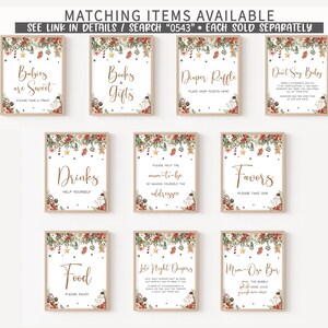 Pu&ograve; includere: Una collezione di cartelli incorniciati con decorazioni a tema natalizio. I cartelli presentano testi come "Babies are Sweet", "Books & Gifts", "Diaper Raffle" e "Don't Say Baby". I cartelli sono in cornici di legno chiaro.