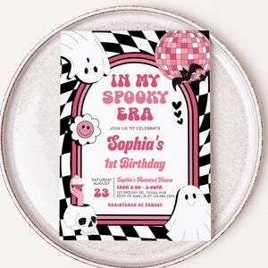 a pink and black birthday party card on a plate