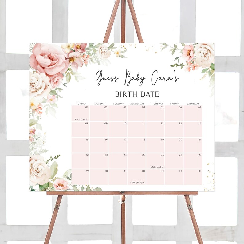 a pink and white floral baby shower calendar on a easel