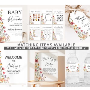 May include: A set of printable baby shower decorations with a floral theme. The set includes a welcome sign, a don't say baby sign, a thank you tag, and water bottle labels. The decorations feature a watercolor floral design with pink, yellow, and green colors.