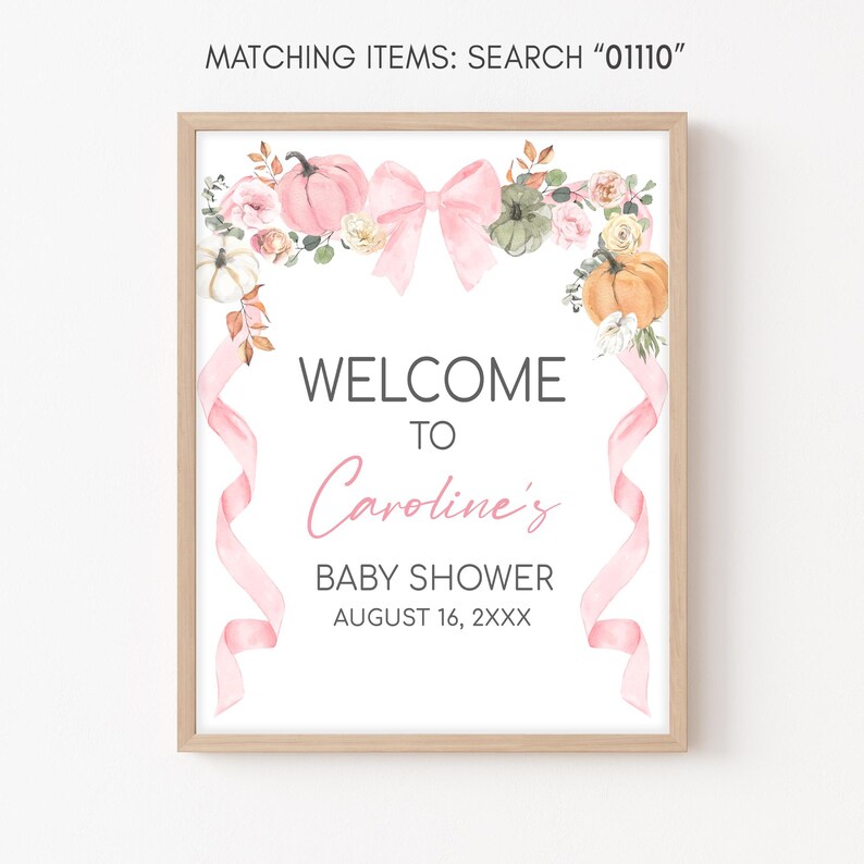 a baby shower sign with a pink ribbon and flowers