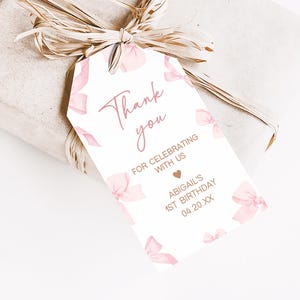 a gift wrapped in brown paper with a pink bow
