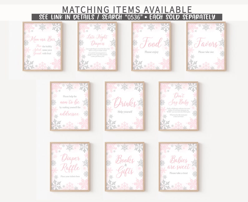 May include: A collection of framed signs with pink and silver snowflake designs. The signs have text such as "Mom osa Bar", "Food", "Favors", "Drinks", and "Babies are sweet". The signs are for a baby shower.