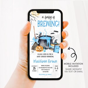 A hand holding a smartphone displaying an invitation for a baby shower.