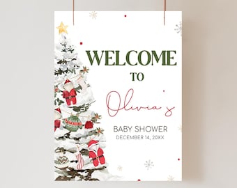May include: A white baby shower welcome sign with a watercolor Christmas tree design. The sign reads "WELCOME TO Olivia's BABY SHOWER DECEMBER 14, 20XX" in green and red text. The tree is decorated with ornaments and snow.