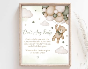 May include: A light green and brown printable sign with a teddy bear holding balloons. The sign says "Don't Say Baby" and includes instructions for a game. Grab a clothespin and pin it on your clothes. If you hear someone say "BABY" you can steal all of their pins. Whoever has the most pins at the end wins!