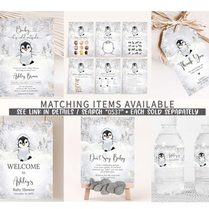 K&ouml;nnte beinhalten: Eine Sammlung von Babyparty-Papeterie mit Pinguin-Motiv. Enth&auml;lt Einladungen, Spielkarten, Dankeskarten, ein Willkommensschild und Wasserflaschenetiketten. Der Text enth&auml;lt "Baby it's cold outside", "Welcome to Ashley's Baby Shower" und "Thank You".