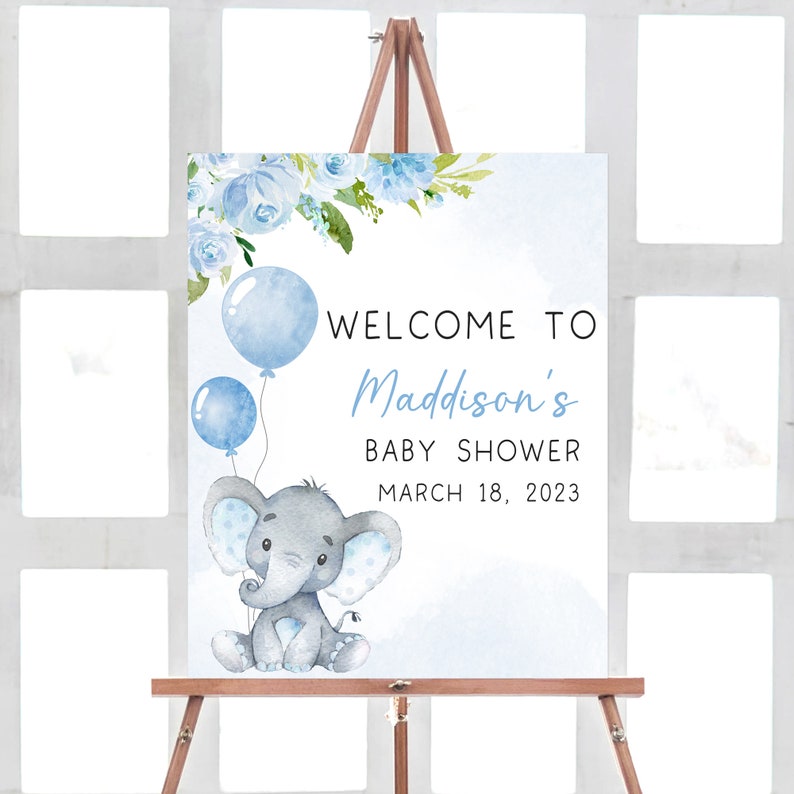 May include: A blue and white baby shower welcome sign with a cute gray elephant holding blue balloons. The sign says "Welcome to Maddison's Baby Shower March 18, 2023".