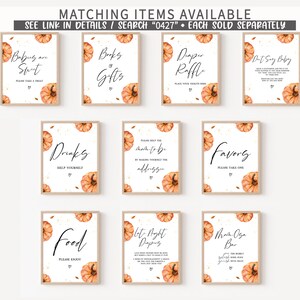 May include: A collection of framed signs with fall-themed designs. Each sign features a watercolor pumpkin and text such as "Babies are Sweet," "Books & Gifts," and "Diaper Raffle." The signs are for a baby shower.