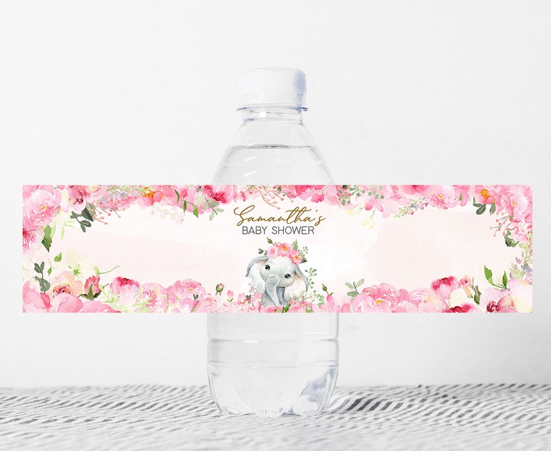Puede incluir: Etiqueta de botella de agua con un dise&ntilde;o floral rosa y una ilustraci&oacute;n de acuarela de un elefante con una corona de flores. El texto en la etiqueta dice "Baby Shower de Samantha".