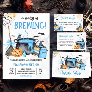 A Halloween-themed baby shower invitation featuring a pot of bubbling soup, jack-o-lanterns, and bats, along with a diaper raffle and books for baby.
