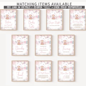 May include: A collection of framed signs with a winter theme, featuring a cute bear illustration in pink and white. The signs include text such as "Babies are Sweet," "Books & Gifts," and "Diaper Raffle." The signs are designed for a baby shower.