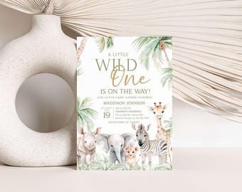 May include: A baby shower invitation with a jungle theme. The invitation features a watercolour illustration of a giraffe, zebra, rhino, elephant, and lion cub. The text on the invitation reads "A Little Wild One is on the Way!" and includes the baby's name, date, time, and location. The invitation also includes the text "Registered at Target."