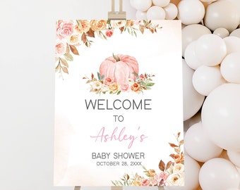 Puede incluir: Un letrero de bienvenida para un baby shower con una calabaza rosa y detalles florales. El letrero dice "Welcome to Ashley's Baby Shower October 28, 2XXX" en fuentes elegantes. Se muestra en un caballete de madera.