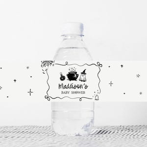 A clear plastic water bottle with a label that says "Maddison's BABY SHOWER" and various decorative elements such as stars and a spider.