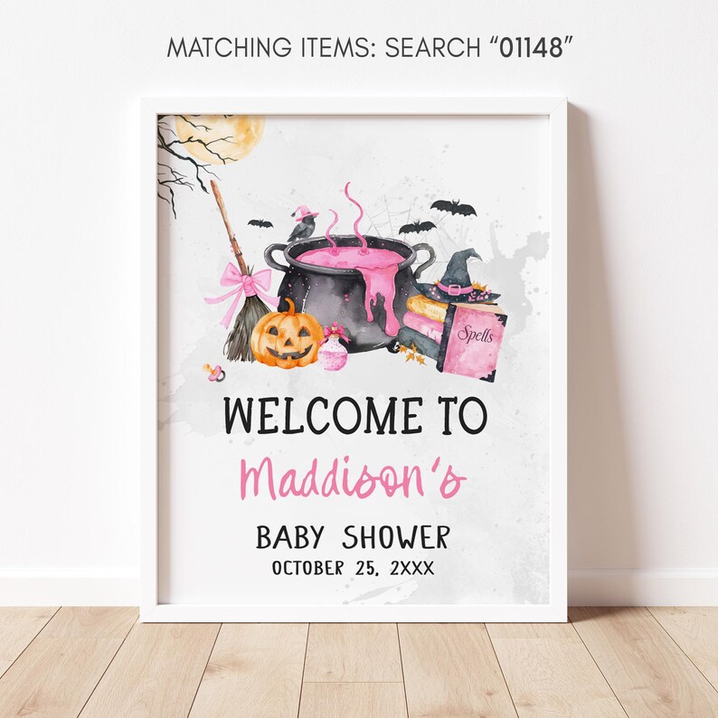 The image is a framed welcome sign for a baby shower, featuring Halloween-themed illustrations such as a cauldron, broomstick, jack-o-lantern, and bats.