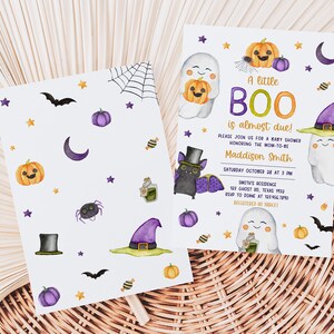May include: Halloween-themed baby shower invitations. The design features watercolor illustrations of ghosts, pumpkins, bats, and a witch's hat. The text reads "A little BOO is almost due!" and includes event details.