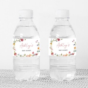 two water bottles with labels on them sitting on a table