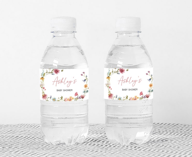 two water bottles with labels on them sitting on a table