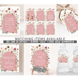 May include: A set of printable baby shower party decorations featuring a floral theme with pink, white, and green colors. The set includes a welcome sign, a don't say baby sign, a thank you tag, water bottle labels, and a game card. The text on the welcome sign reads "Welcome to Ashley's Baby Shower March 2000X".