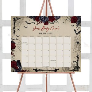 Peut inclure: Panneau de baby shower sur le thème d'Halloween sur un chevalet. Le panneau présente un calendrier avec le texte "Guess Baby Cara's BIRTH DATE". Le design comprend des roses rouges, des chauves-souris, des toiles d'araignées et un corbeau.