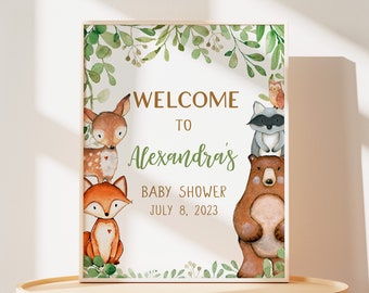 May include: Welcome to Alexandra's Baby Shower sign with a green leafy border and woodland animals including a deer, fox, raccoon, and bear. The date of the shower is July 8, 2023.
