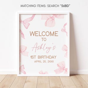 a pink and gold welcome sign on a white wall