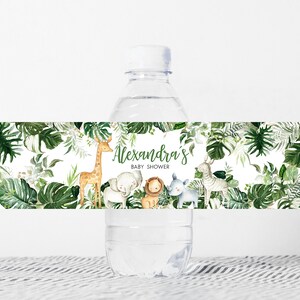 May include: Water bottle label with a jungle theme. The label features a giraffe, elephant, lion, and zebra surrounded by green leaves. The text on the label reads "Alexandra's Baby Shower".