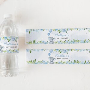 Op de afbeelding: Blauwe en witte waterfleslabels voor een babyshower met een schattig olifantje en ballonnen. De labels zeggen "Maddison's Baby Shower".
