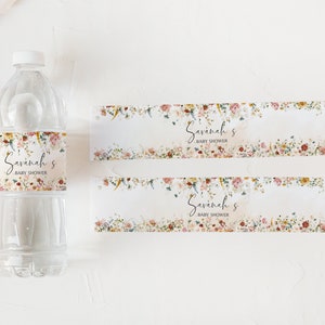 Pu&ograve; includere: Due etichette per bottiglie d'acqua floreali con il testo "Savannah's Baby Shower" stampato su di esse. Le etichette sono progettate con un motivo floreale ad acquerello in tonalit&agrave; di rosa, rosso, giallo e verde.