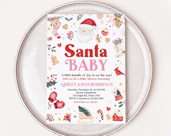 Op de afbeelding: Een feestelijke babyborrel uitnodiging met een Santa thema. De uitnodiging toont de woorden "Santa BABY" in rood en roze, samen met vakantie-illustraties zoals de kerstman, een sneeuwbol en een kerstboom. De uitnodiging ligt op een wit bord.