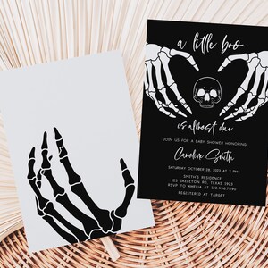 K&ouml;nnte beinhalten: Zwei Halloween-Babyparty-Einladungen. Eine ist hellgrau mit einer schwarzen Skelett-Hand-Grafik. Die andere ist schwarz mit wei&szlig;em Text und Skelett-Hand-Grafiken. Der Text lautet "a little boo is almost due".