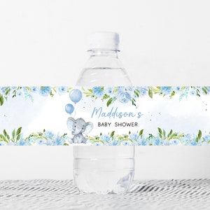 Op de afbeelding: Blauw en groen bloemenwaterfleslabel met een schattige grijze olifant die ballonnen vasthoudt. Het label zegt "Madisson's Baby Shower".