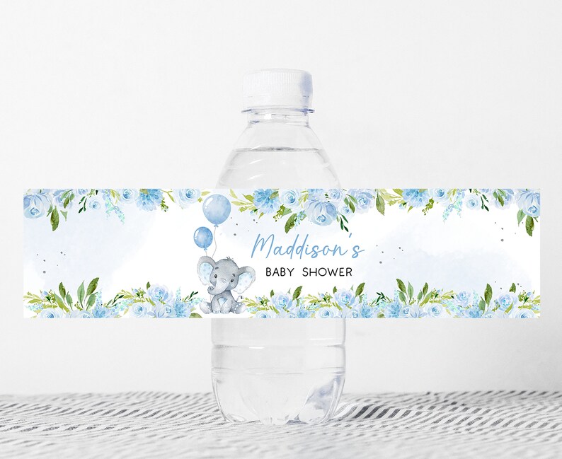 Op de afbeelding: Blauw en groen bloemenwaterfleslabel met een schattige grijze olifant die ballonnen vasthoudt. Het label zegt "Madisson's Baby Shower".