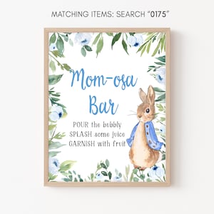 Peut inclure: Une pancarte blanche avec une bordure florale bleue et une illustration aquarelle d'un lapin. La pancarte indique "Mom-osa Bar" et comprend les instructions suivantes : "POUR the bubbly, SPLASH some juice, GARNISH with fruit".