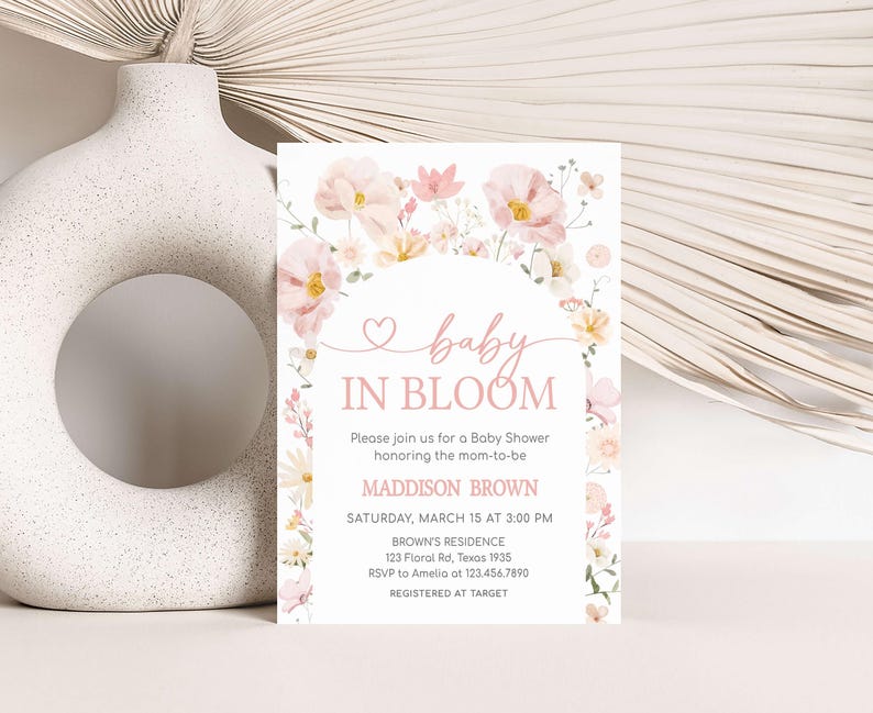 a baby in bloom baby shower is displayed next to a vase