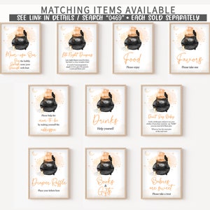 May include: A collection of framed signs with a Halloween theme. Each sign features a black cauldron with orange steam and a raven, with text such as "Mom-osa Bar," "Food," and "Favors." The signs are set against a light beige background.