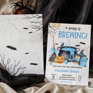 A Halloween-themed baby shower invitation featuring bats, a cauldron, and a pumpkin, with the text "a baby is BREWING!"