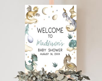 May include: Welcome to Maddison's Baby Shower sign with a white background and watercolor illustrations of dragons, stars, and clouds. The text reads "Welcome to Maddison's Baby Shower August 16, 2XXX".