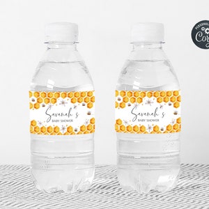 May include: Two clear plastic water bottles with white labels featuring a honeycomb pattern and the text "Savannah's Baby Shower".