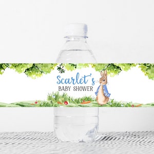 May include: Water bottle label with a watercolor illustration of a rabbit in a blue jacket, green foliage, and the text "Scarlet's Baby Shower".