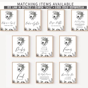 May include: A collection of framed signs with a skull and floral design. The signs have various text, including "Drinks," "Favors," and "Food." The signs are in a light wood frame with black and white graphics. The text "Matching Items Available" is at the top.