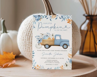 May include: A baby shower invitation card with the text "OUR LITTLE PUMPKIN IS ON THE WAY!" features a blue truck carrying pumpkins. The card is decorated with blue and orange floral accents and includes event details.