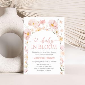 a baby in bloom baby shower is displayed next to a vase